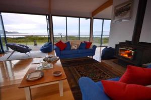 South BrunyMures Cloudy Bay Retreat的客厅设有蓝色的沙发和壁炉