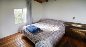 瓜莱瓜伊Cabañas Aguaflorida的一间卧室配有一张带毯子的床和窗户