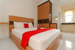 巨港RedDoorz Plus near Palembang Square Mall的一间卧室配有一张大床,上面有红毯