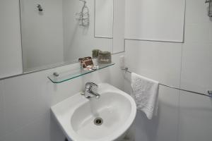 库克山村库克山高山旅馆的白色的浴室设有水槽和镜子