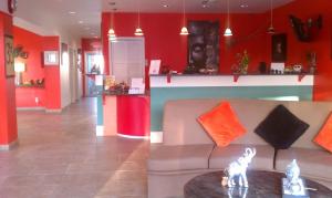 德尔里奥Whispering Palms Inn的客厅设有红色的墙壁、一张沙发和一张桌子