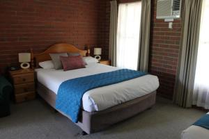 吉朗沃恩瓦尔贵族酒店的卧室设有一张砖墙内的大床