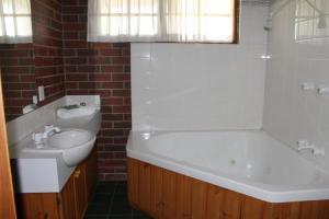 吉朗沃恩瓦尔贵族酒店的浴室配有白色浴缸、盥洗盆和浴缸。