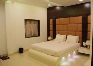 巴加Hotel Rezo's的一间卧室配有一张大床和木制床头板