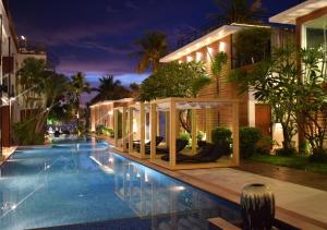 芭东海滩La Flora Resort Patong - SHA Extra Plus的大楼前的游泳池