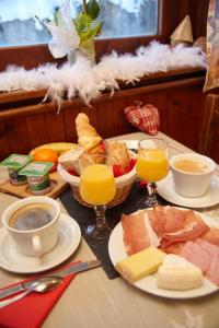 莱孔塔米讷蒙茹瓦盖里纳特酒店的餐桌上放有食物和橙汁的盘子