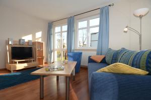 奥斯赛拜-塞林Villa Seerose - Appartement 01的客厅配有蓝色的沙发和桌子