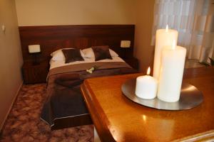 莫龙格伊雷娜酒店的一间卧室配有一张带两张蜡烛的桌子。
