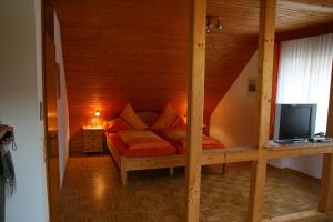 诺伊马根-德赫龙科尔斯特范葡萄酒庄&酒店的木制客房内的一间卧室,配有一张床