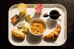 巴黎国际雷斯当斯酒店的托盘,包括早餐食品和咖啡及羊角面包