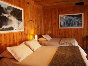 科克拉内Hotel Último Paraíso的木镶板客房内的两张床