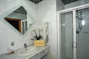 罗迪-加尔加尼科Hotel Borgo Marina的一间带水槽、淋浴和镜子的浴室