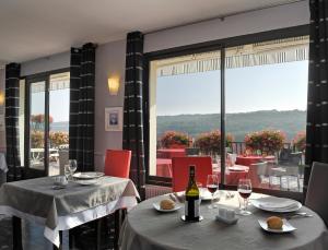 Chassey-le-Camp罗曼营地酒店的餐厅设有两张桌子和一瓶葡萄酒