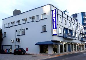 伊达贾伊Hotel Vitoria - Itajaí的白色的建筑,上面标有读取酒店的标志