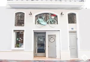 阿利坎特Hotel Smile & Co Hostal Boutique的一座白色的建筑,一辆自行车挂在门上