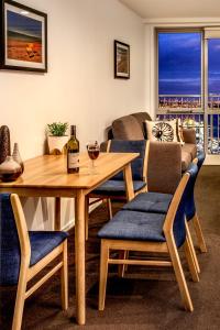 奥克兰巴克莱套房酒店的客厅配有一张桌子和一杯葡萄酒