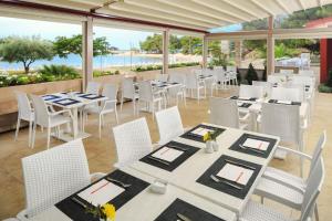 乌马格Apartments Stella Plava Laguna的一间设有白色桌椅的海洋餐厅