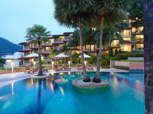 卡塔海滩Chanalai Flora Resort, Kata Beach的酒店前方的棕榈树游泳池