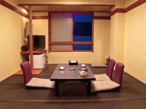 京都里茂旅馆的客厅配有桌子和紫色椅子
