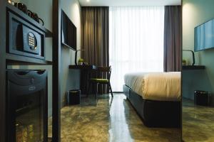 曼谷爵世曼谷酒店的酒店客房配有一张床、一张书桌和一台电视。