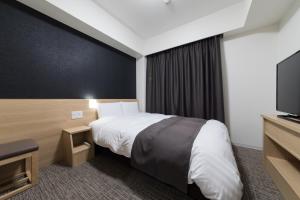 多美迎松山天然温泉酒店客房内的一张或多张床位