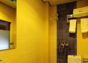 贵阳骏怡连锁贵州贵阳云岩区八鸽岩路店的带淋浴和卫生间的黄色浴室