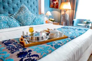 迪拜玛立纳比布鲁斯酒店的床上的食品和饮料托盘
