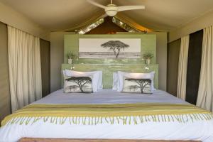 白河Muluwa Lodge的一间卧室配有一张大床和吊扇