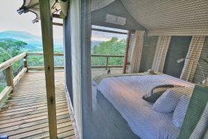 白河Muluwa Lodge的阳台卧室(带一张床)