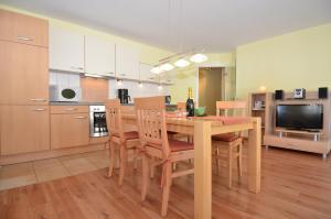奥斯赛拜-塞林Villa Seerose - Appartement 06的厨房以及带木桌和椅子的用餐室。