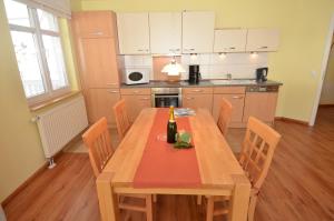 奥斯赛拜-塞林Villa Seerose - Appartement 06的厨房配有木桌和一瓶葡萄酒