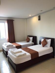 伊缇天福Nhu Ngoc Homestay的酒店客房设有两张床和窗户。