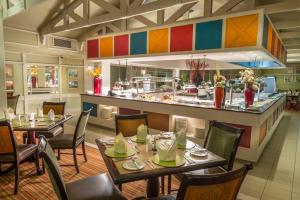 哈博罗内哈博罗内大棕榈皮尔蒙沃蒙特酒店的一间带桌椅的餐厅和一间厨房