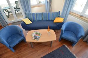 奥斯赛拜-塞林Villa Seerose - Appartement 07的客厅配有2把蓝色椅子和桌子