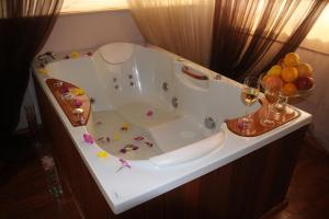 特罗扬特罗扬广场酒店的白色浴缸,备有葡萄酒和水果