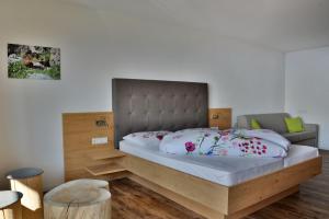 马兰扎Hotel Pfeiferhof的一间卧室配有一张大床和木制床头板