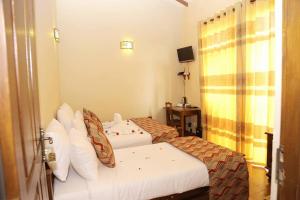 努沃勒埃利耶湖景私人酒店的酒店客房设有两张床和电视。