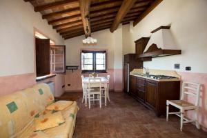 斯佩洛Terre Del Cantico Country House的厨房以及带沙发和桌子的客厅。