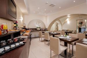 罗马戴美塔酒店的一间带桌椅的餐厅以及一间自助餐