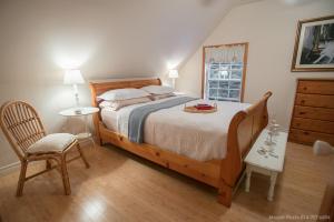 科蒂库克La Maison Bleue du Lac Wallace的一间卧室配有一张大床和一把椅子