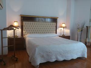 阿尔巴塞特卡迪纳尔酒店的卧室配有一张白色床、两张桌子和两盏灯。