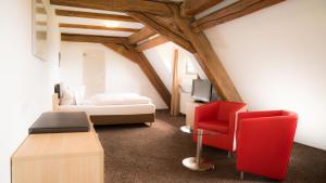 豪森奥博韦雷娜豪亨卡普芬豪弗加特酒店的一间卧室配有一张床和一张红色椅子