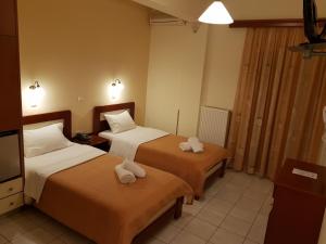 卡拉马塔Hotel Nevada Kalamata的酒店客房,配有两张带毛巾的床