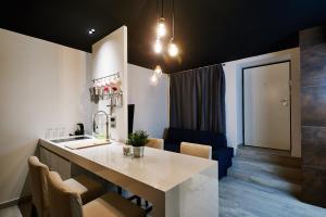 萨格勒布Apartment and Rooms Marinac的厨房配有带椅子的柜台和水槽