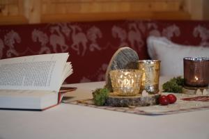 纳瑟尔文勒Landhaus Schatz的一张桌子,上面有书和蜡烛,还有一张带灯的盘子