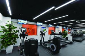 北京北京国宾酒店的健身房设有一排跑步机和电视