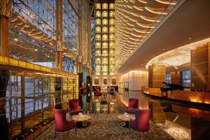 迪拜The Meydan Hotel Dubai的大堂设有三角钢琴和桌椅