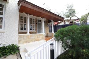 普卡Diyar Villas Puncak Q4/11的白色栅栏房子的门廊