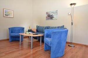 奥斯赛拜-塞林Villa Seerose - Appartement 11的客厅配有蓝色椅子、桌子和沙发