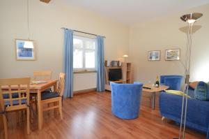 奥斯赛拜-塞林Villa Seerose - Appartement 11的客厅配有桌子和蓝色沙发